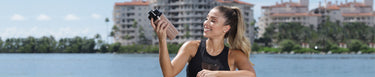 Active woman outside holding a fitness tumbler